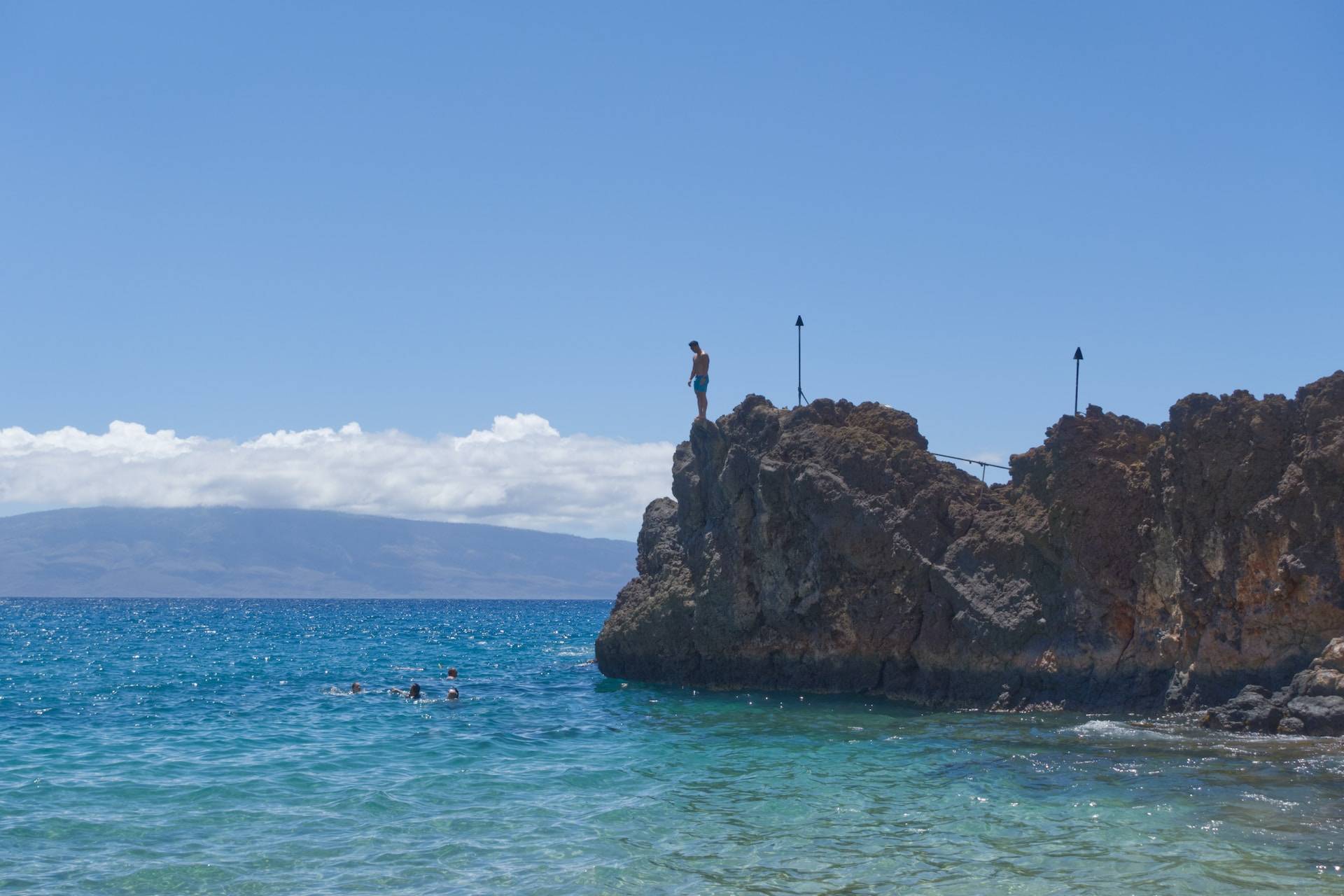 jumping from a rock at Ka'anapali Beach